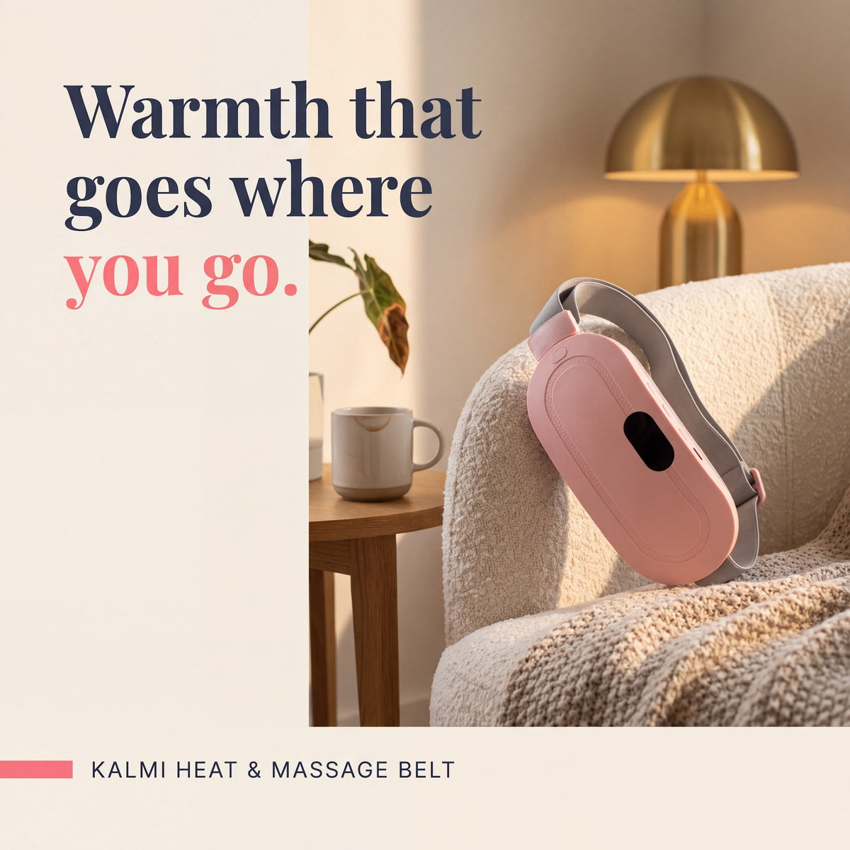 Kalmi pink cordless heat and massage belt for period days, resting on a cream armchair